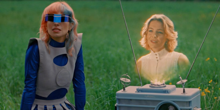 Blue visor and sculptural costumes in the Any Way video by L’Impératrice featuring Maggie Rogers.