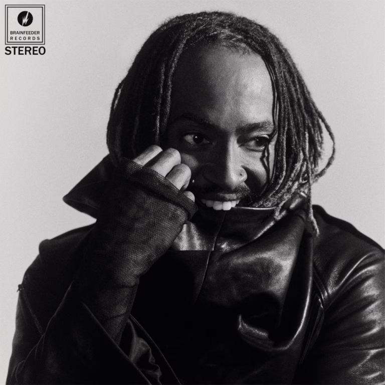 Thundercat smiling behind his jacket collar on the black-and-white Distracted album cover.