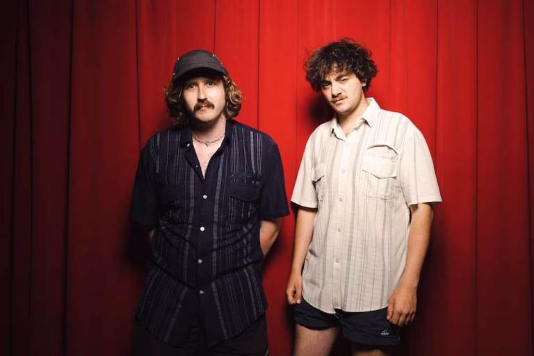Getdown Services duo Josh Law and Ben Sadler standing in front of red curtains